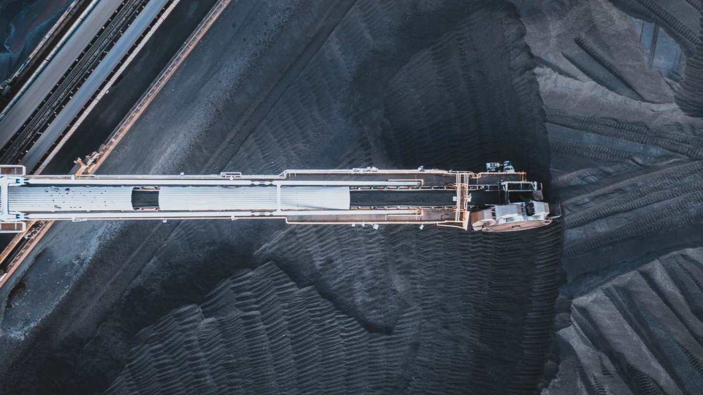 Aerial view of a stacker-reclaimer feeding a coal stockyard conveyor system